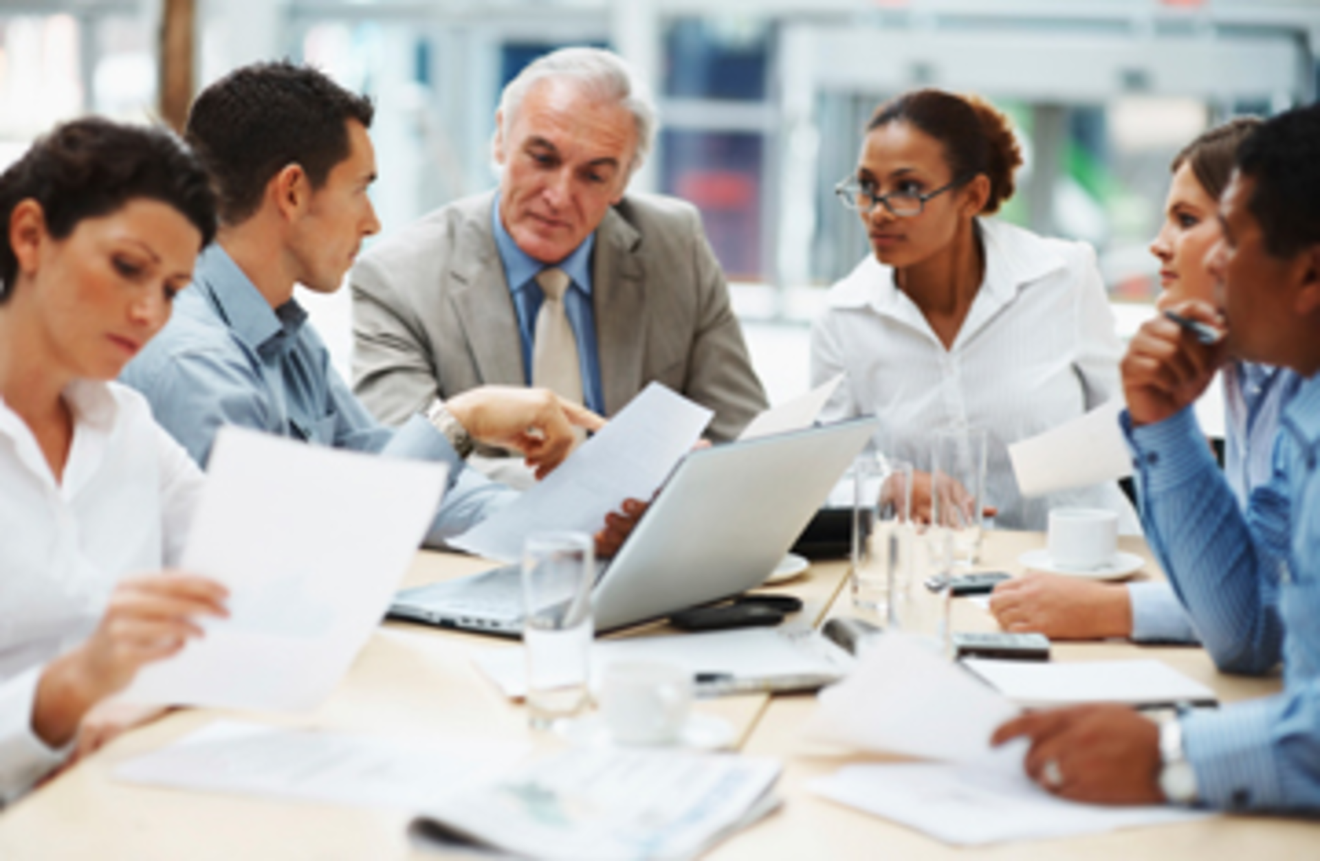 Business people discussing work on laptop at a meeting