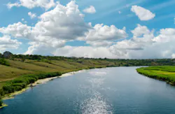 river with reflections and blue cloudy sky