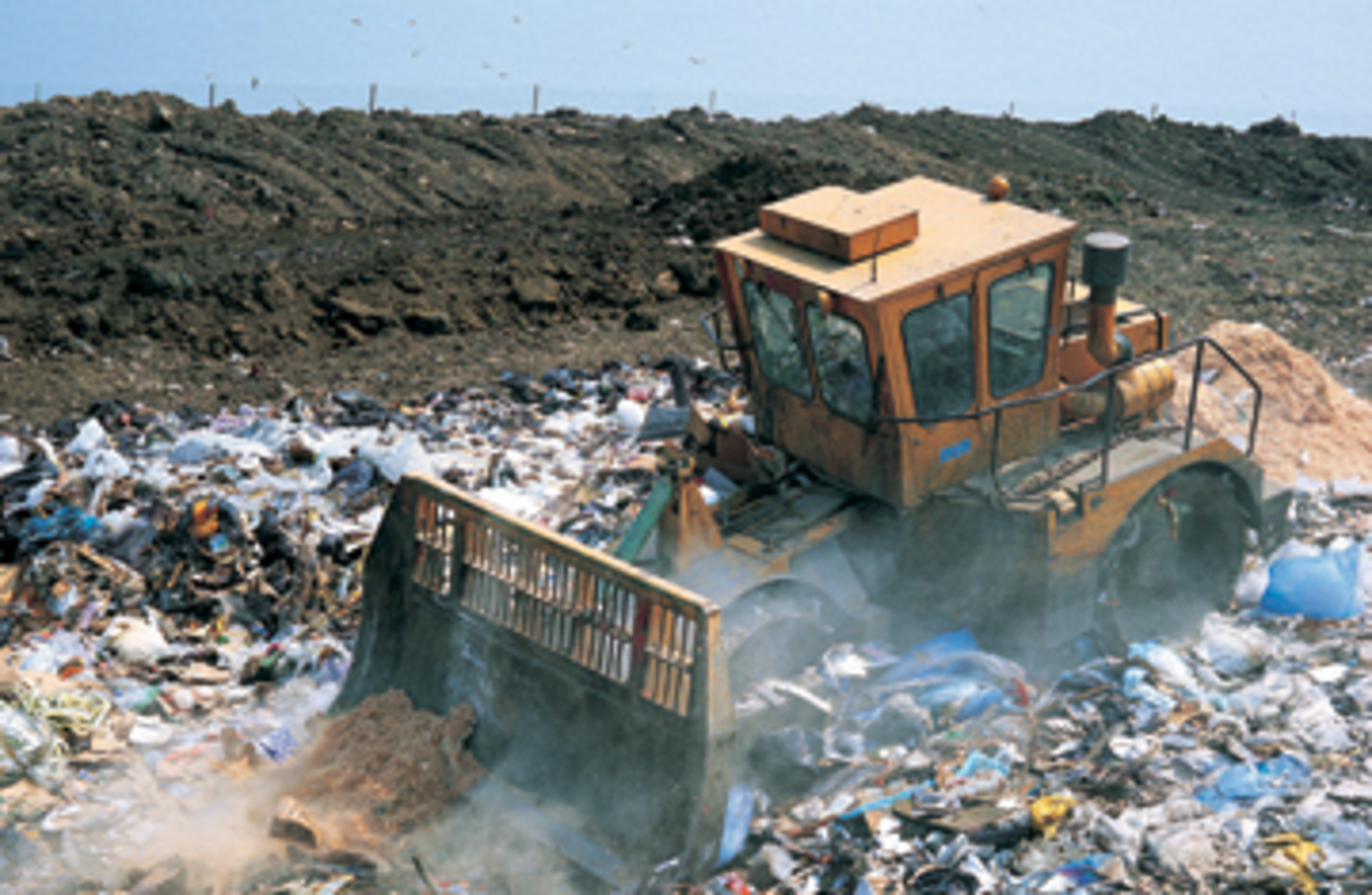 Bulldozer working on landfill site, UK