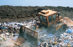 Bulldozer working on landfill site, UK Bulldozer working on landfill site, UK