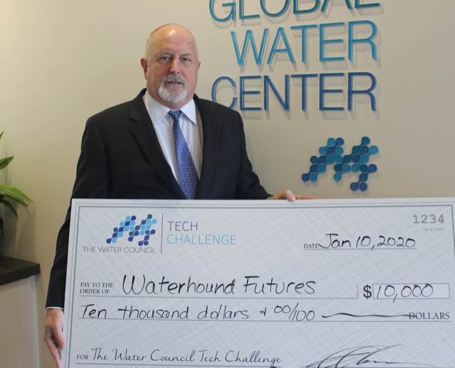 Tony Jones, Ph.D, of Waterhound Futures accepts a check.