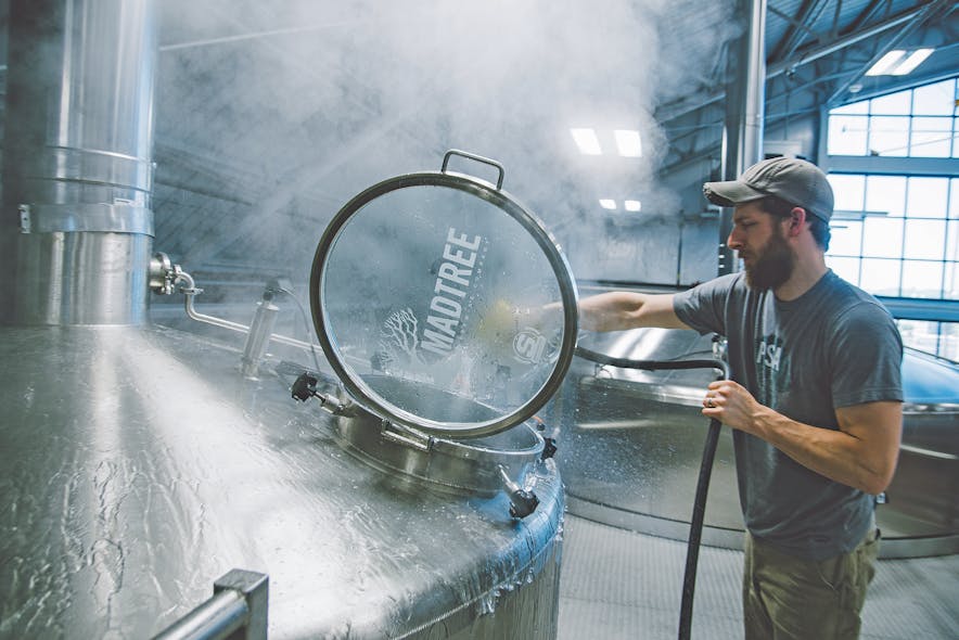 Director of Brewing Operations Matt Rowe sprays out the mash/lauter tun on MadTree&rsquo;s 126 BBL production brewhouse during a brew day.