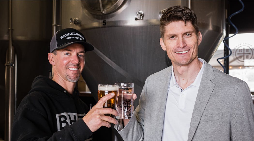 Jason Carvalho President &amp; CEO of BarrelHouse Brewing and Dr. David Stuckenberg COO &amp; Board Vice Chairman of Genesis Systems celebrate the partnership.