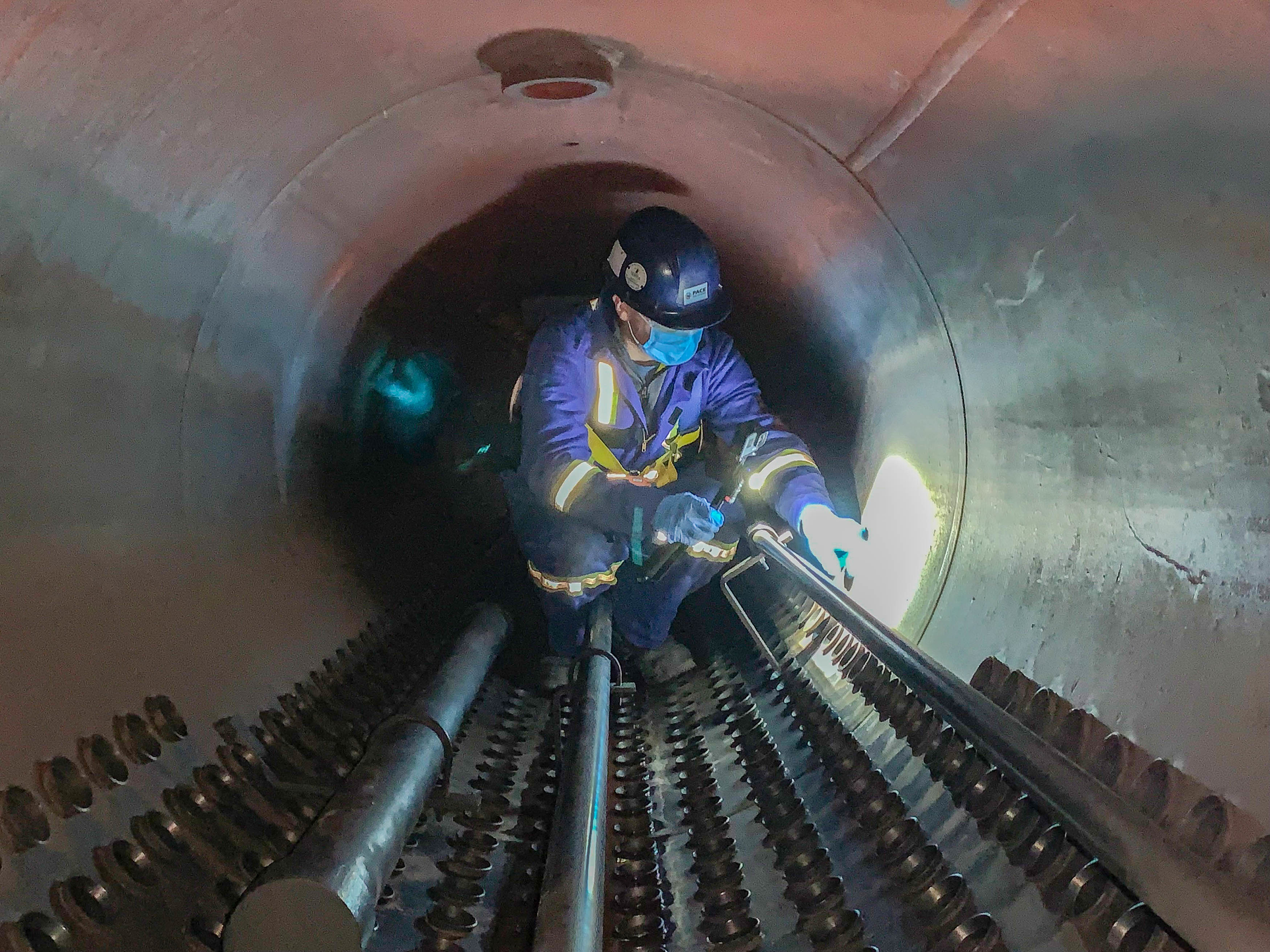 Water treatment specialist personally inspecting the steam drum of a boiler.