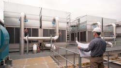 An engineer looks over a new cooling tower installation. An engineer looks over a new cooling tower installation.
