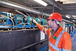 A worker inspects a Qdos peristaltic chemical metering pump. A worker inspects a Qdos peristaltic chemical metering pump.