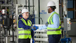 An Ecolab associate speaks with a colleague about water treatment in an industrial facility.
